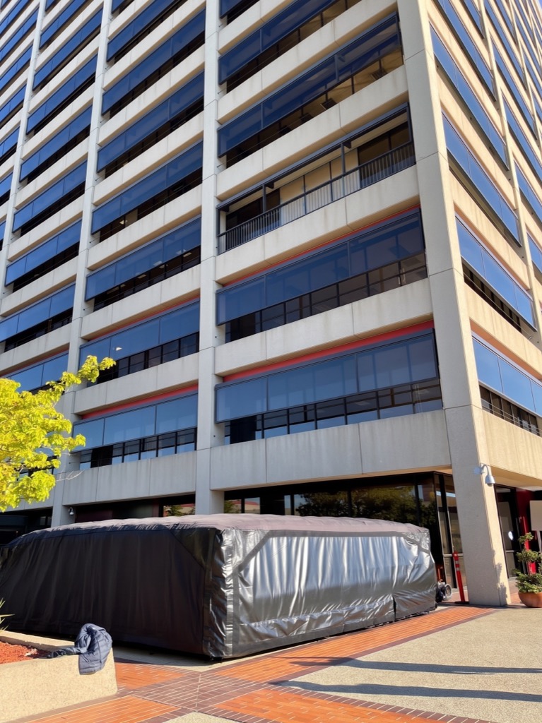 Large inflatable rescue and impact-protection air cushion deployed at the base of a high-rise building